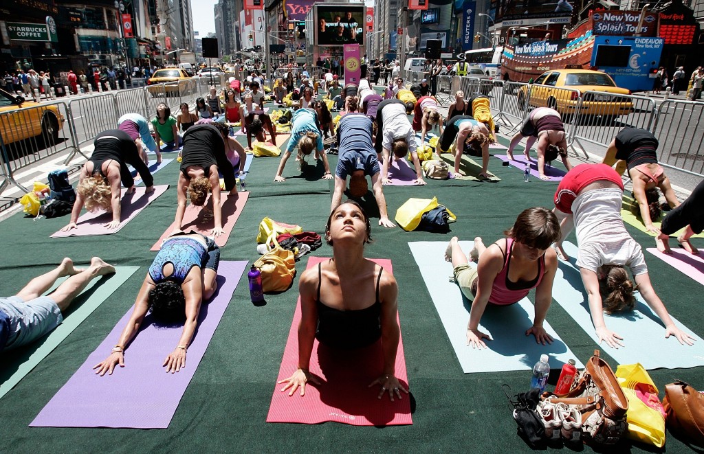 NEW YORK - JUNE 21: LeTania Kirkland (C) and other yoga enthusiasts from across the country participate in the annual "Summer Solstice in Times Square Yoga-thon" June 21, 2007 in New York City. The summer solstice is the first official day of summer and the longest day of the year. (Photo by Mario Tama/Getty Images)